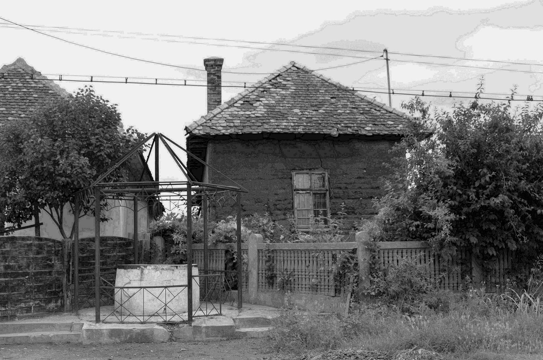 Fațada unei construcții din pământ bătut, fără tencuială.