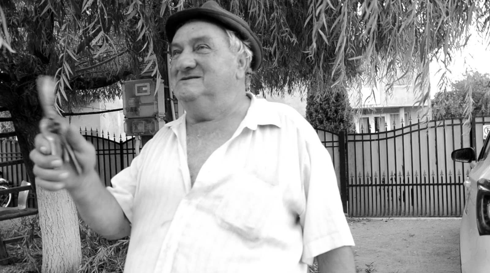 O persoană relatează despre construcțiile din pămât bătut din zonă. Imaginea este un stop-cadru dintr-un interviu cu locuitorii satelor din zona cercetată.