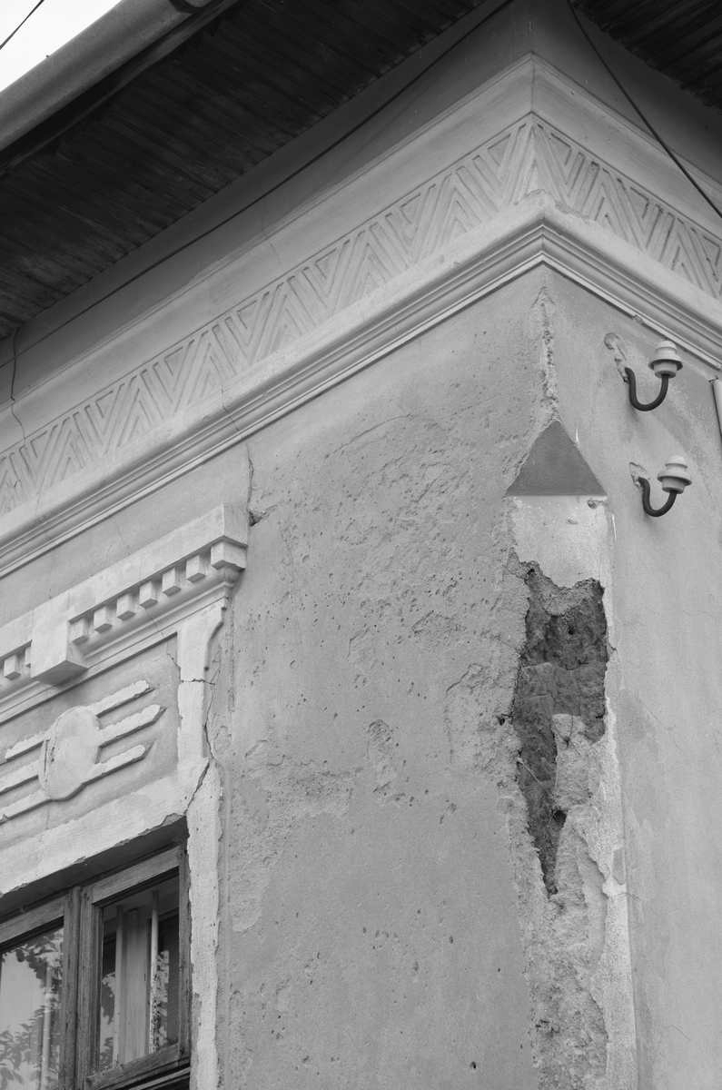 Detaliu cu peretele unei construcții din pământ, parțial deteriorat.
